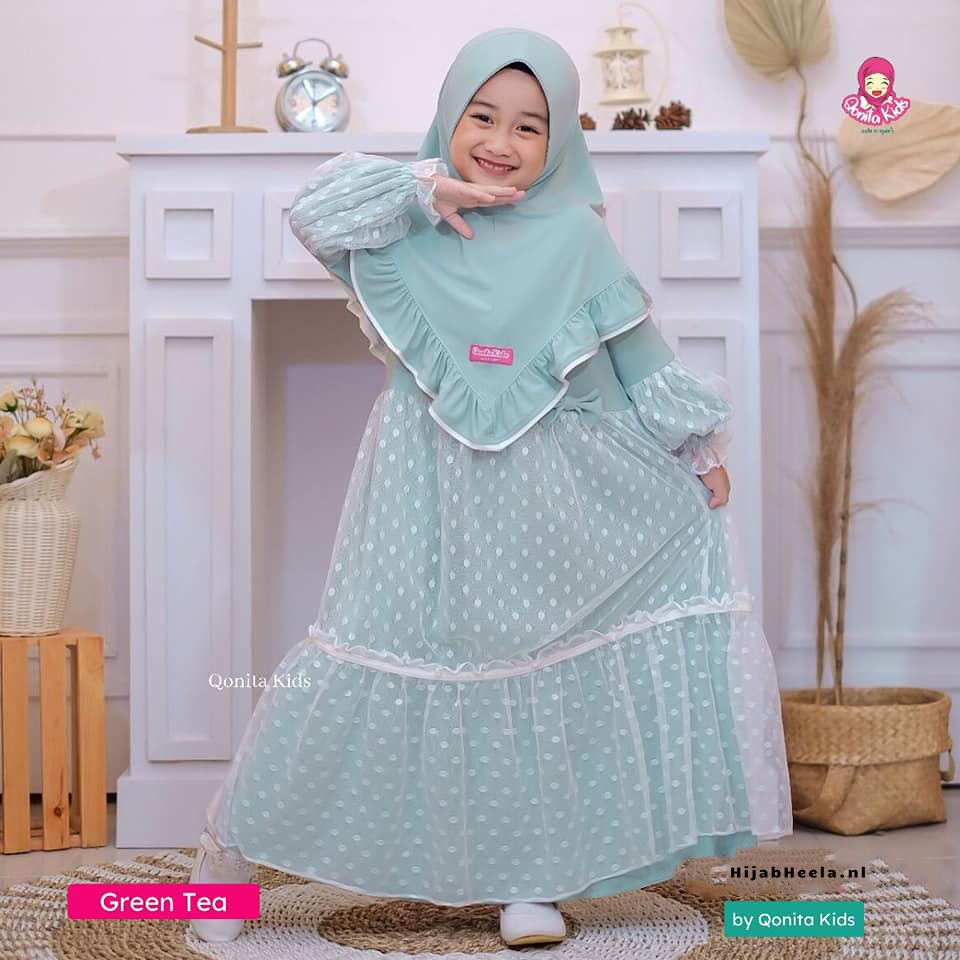 a woman in a white dress holding a tennis racket